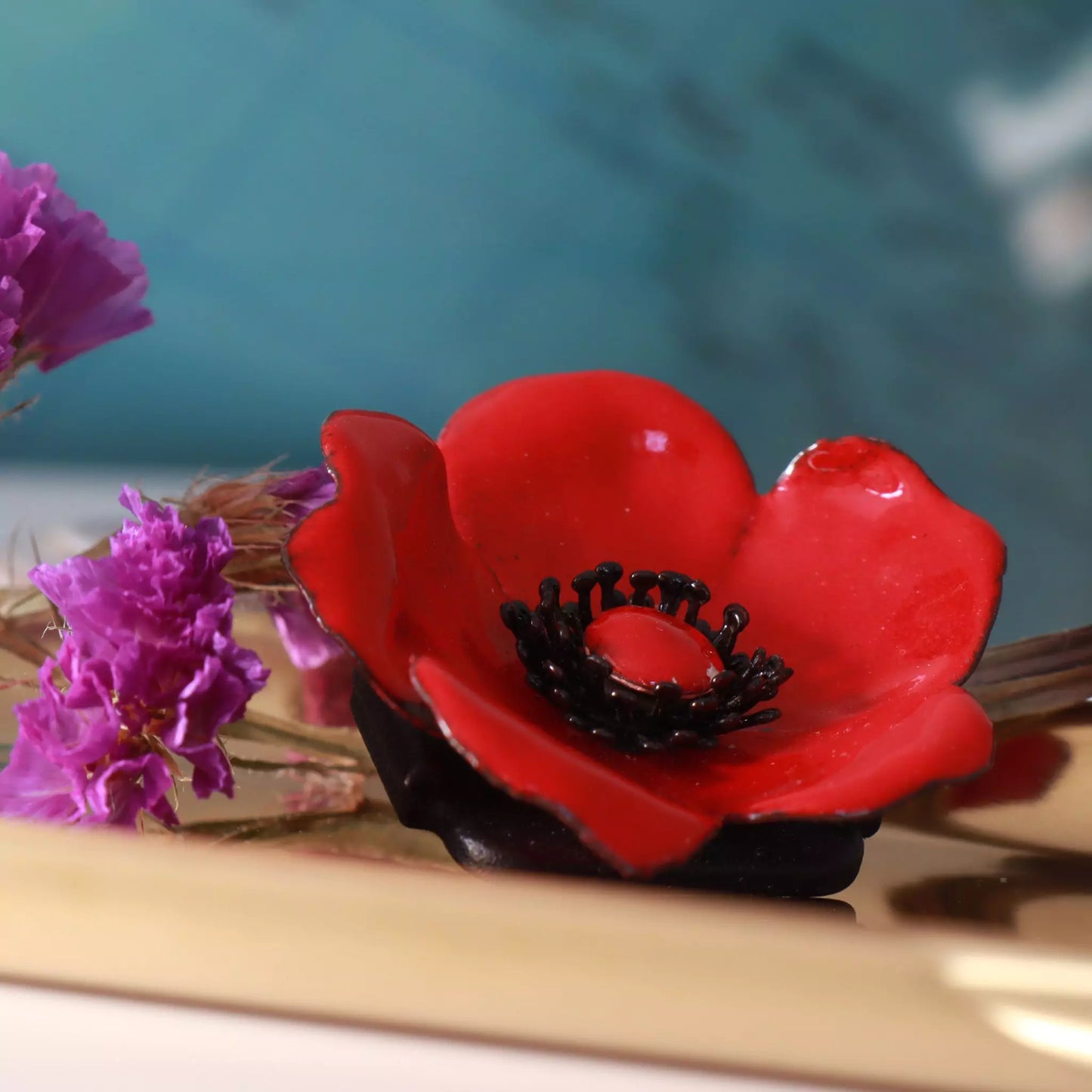 Florale Brosche rot. Dunkle Staubblätter, die für einen sanften Kontrast sorgen