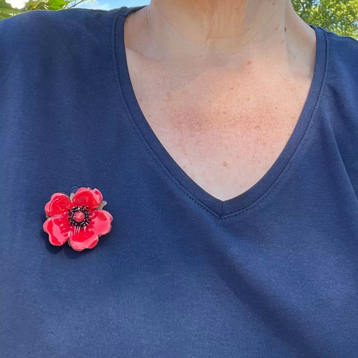 Florale Brosche getragen – emaillierte Rose am Shirt