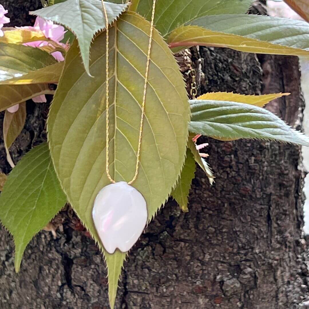 Emaillierten Kirschblütenblatt Anhänger im Garten. Ein Hauch von ewigem Frühling.