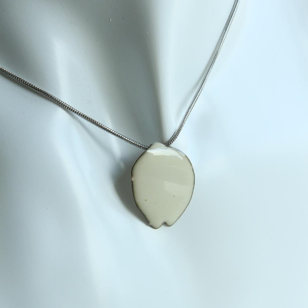 Entdecken Sie den Sakura-Anhänger, ein raffiniertes Schmuckstück, inspiriert von japanischen Kirschblüten. Perfekt für einen eleganten und lässigen Stil. Sakura-Blumenanhänger wird auf einer Büste getragen