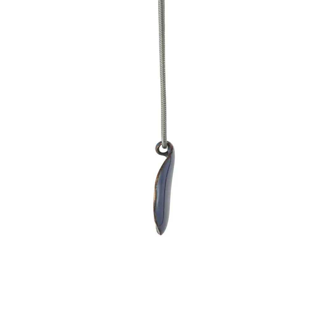 Lilafarbener Schmuck-Anhänger, Seitenansicht, auf weißem Hintergrund