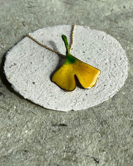 das Ginkgoblatt in herbstlichen Farbtönen, halb grün, halb golden.