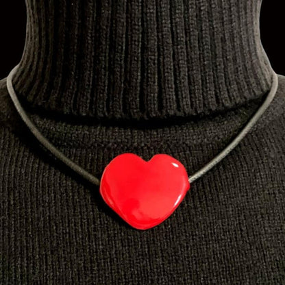  Rot Anhänger mit Lederkordel. Auf einem schwarzen Rollkragenpullover, der Schmuck der Liebe ist perfekt