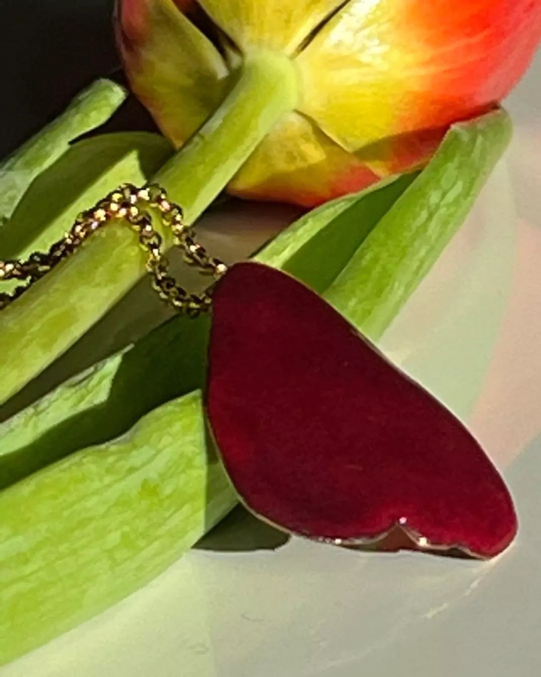 Pétale de rose émaillé, couleur rubis, visible à l'atelier de Karlsruhe, ici avec une fleur de tulipe en arriere plan